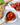 Spoonful of Zia Pia tomato sauce on a white background with tomatoes