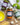 Three jars of different pestos and spreads on a wooden board with basil, garlic, and pasta
