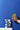 Hand holding a glass of lemonade with a blue background and a box of Momofuku Siam Iced Tea.