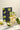 Glass of iced tea with lime and mint leaves next to a package labeled 'Momojito' on a marble surface.