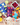 Three colorful tea bags with fruit and a mesh bag on a wooden surface