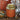 Gold and orange tea canister with decorative elements on a wooden surface