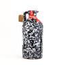 A ceramic bottle of extra virgin olive oil with a hand-painted black and whiten pattern, cork stopper, and a red label.