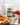 Jar of Zia Pia artichoke and garlic spread on a wooden table with tomatoes and bread.