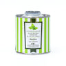 Tin of green and white striped galantino basil flavored oil on a white background