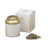 A tin container of Ginger Lemon Herbal Tea by La Via del Tè with its contents displayed in front and a white box in the background.