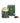 A green La Via del Tè tea box and a gold-colored tin with the name 'Camille' on it, alongside loose leaf green tea and a small pile of dried tea leaves and flowers.