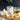 Olive oil canister with garlic and pasta on a wooden board