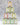 Tins of various flavors of olive oils stacked in a pyramid on a white counter with a gray background