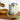 Tin of rosemary flavored olive oil on a wooden board with rosemary sprigs and a oil being poured into a bowl