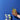 Hand holding a glass of lemonade with a blue background and a box of Momofuku Siam Iced Tea.