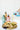Person pouring olive oil over bread on a wooden board with colorful ceramic bottles of olive oil in the backlground