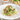 Plate of green pasta with broccoli and bacon on a wooden table