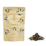 Tea package with floral design and loose tea leaves on a white background