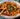Pasta dish with basil in a bowl on a table