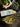 Pasta dish with green vegetables on a wooden table, featuring a box of pasta and fresh ingredients.