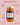 Jar of Zia Pia tomato pesto with text highlighting product features on a pink background