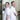 Two men in white shirts standing back-to-back in a warehouse setting.