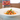 White dish of Penne with sauce and basil with a package of penne in the background