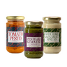 Three jars of different pesto and spread products on a white background