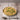 Risotto with peas in a white bowl on a wooden table