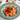 Trottole pasta dish with sauce and basil in a green pasta bowl on a white background
