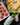 Green hand painted ceramic bottle of extra virgin olive oil on a dark counter with pasta and tomatoes