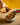 Hand pouring a bottle of white truffle olive oil over a bowl of roasted veggies on a cork colored counter 
