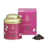A product image featuring a tin and box of Violetta loose leaf tea by La Via del Té. The tin is gold with a floral design, and the box is pink with the name 'Violetta' written on it.